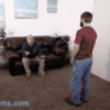 Man standing talking to man on couch