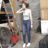 Girl in warehouse wearing tank top, jeans and white canvas sneakers.